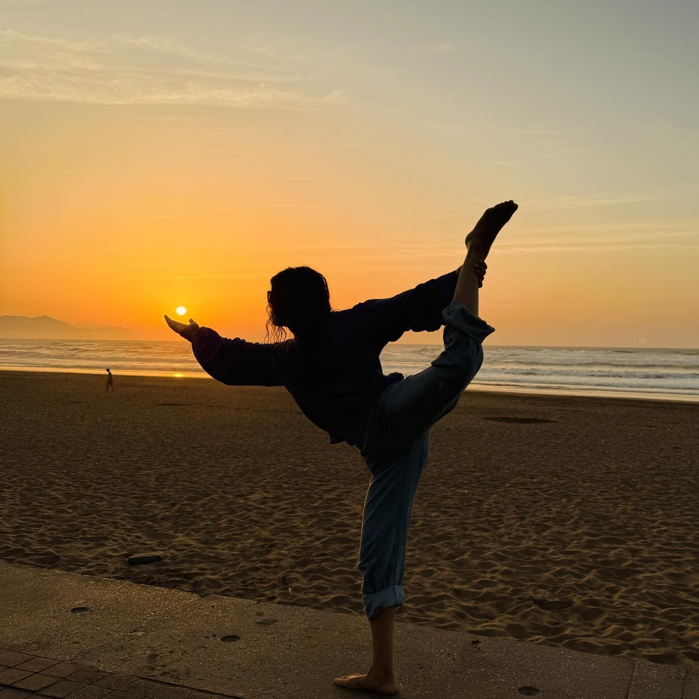 Elisa practising yoga by the sea at sunset